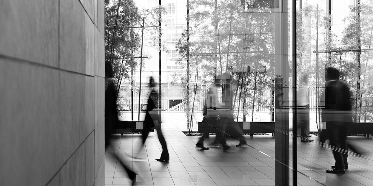 a blurred motion picture showing business people walking in an office building foyer